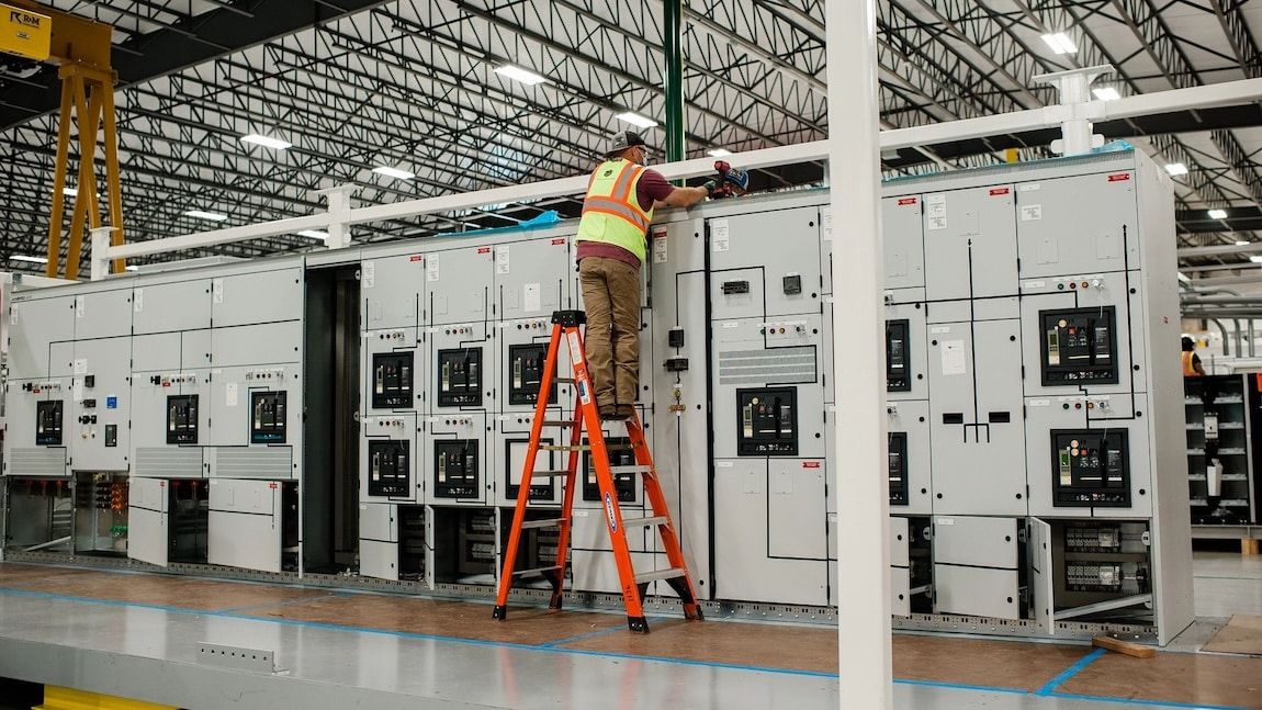 A data center construction employee works on securing the facility's towers.